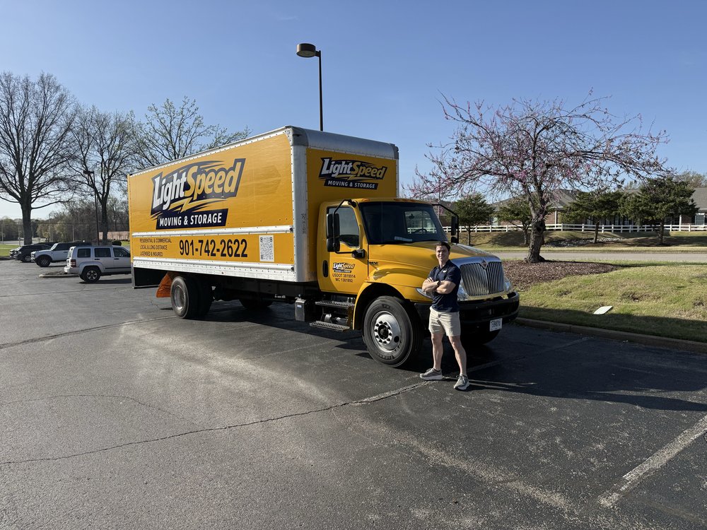 Yellow truck, blue sky, Garrett at the bumper.